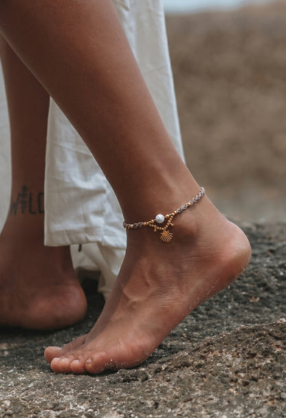 Stilingas papuosalas ant kojos. Rudo siulo apyranke su aukso detalemis. Boho apyranke.