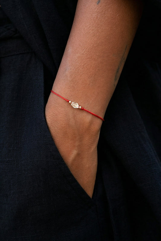 Raudono siulo apyranke su auksu ir kristalu.